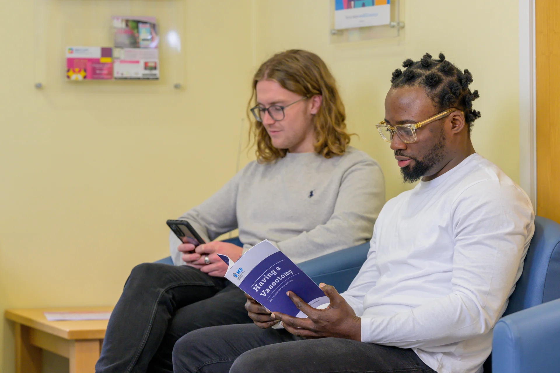 A client holds open a booklet titled 'Having a Vasectomy'.